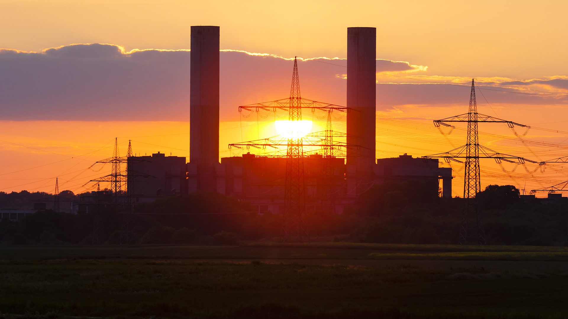 sunset behind coal-fired power plant